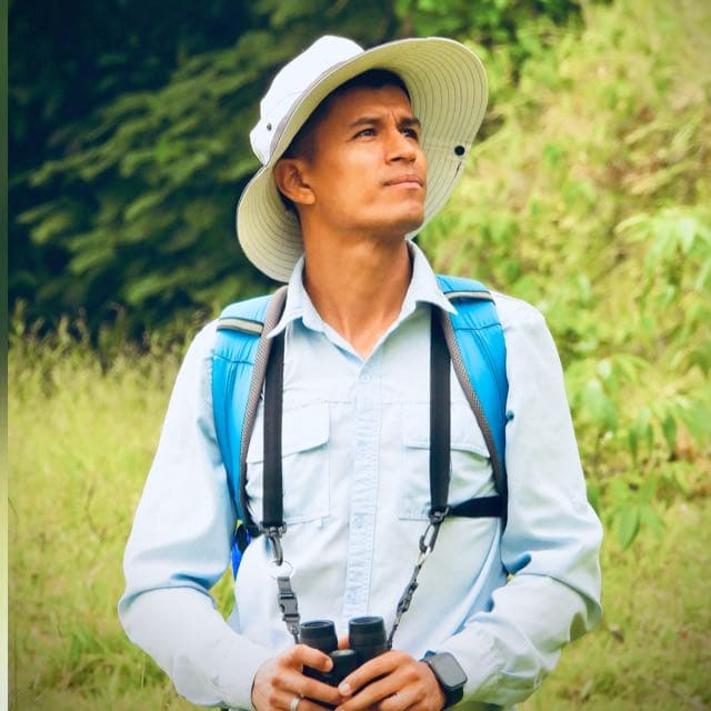 Cristian Enciso con binoculares durante una salida de avistamiento de aves