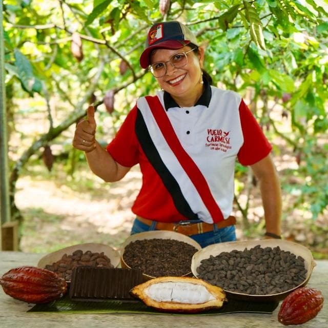 María Umaña con el uniforme de Vuelo Carmesí junto a mazorcas y granos de cacao